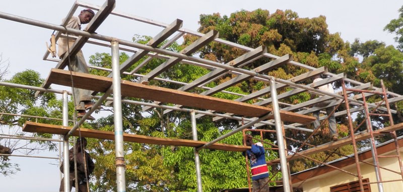 Team building a solar canopy frame on scaffolding
