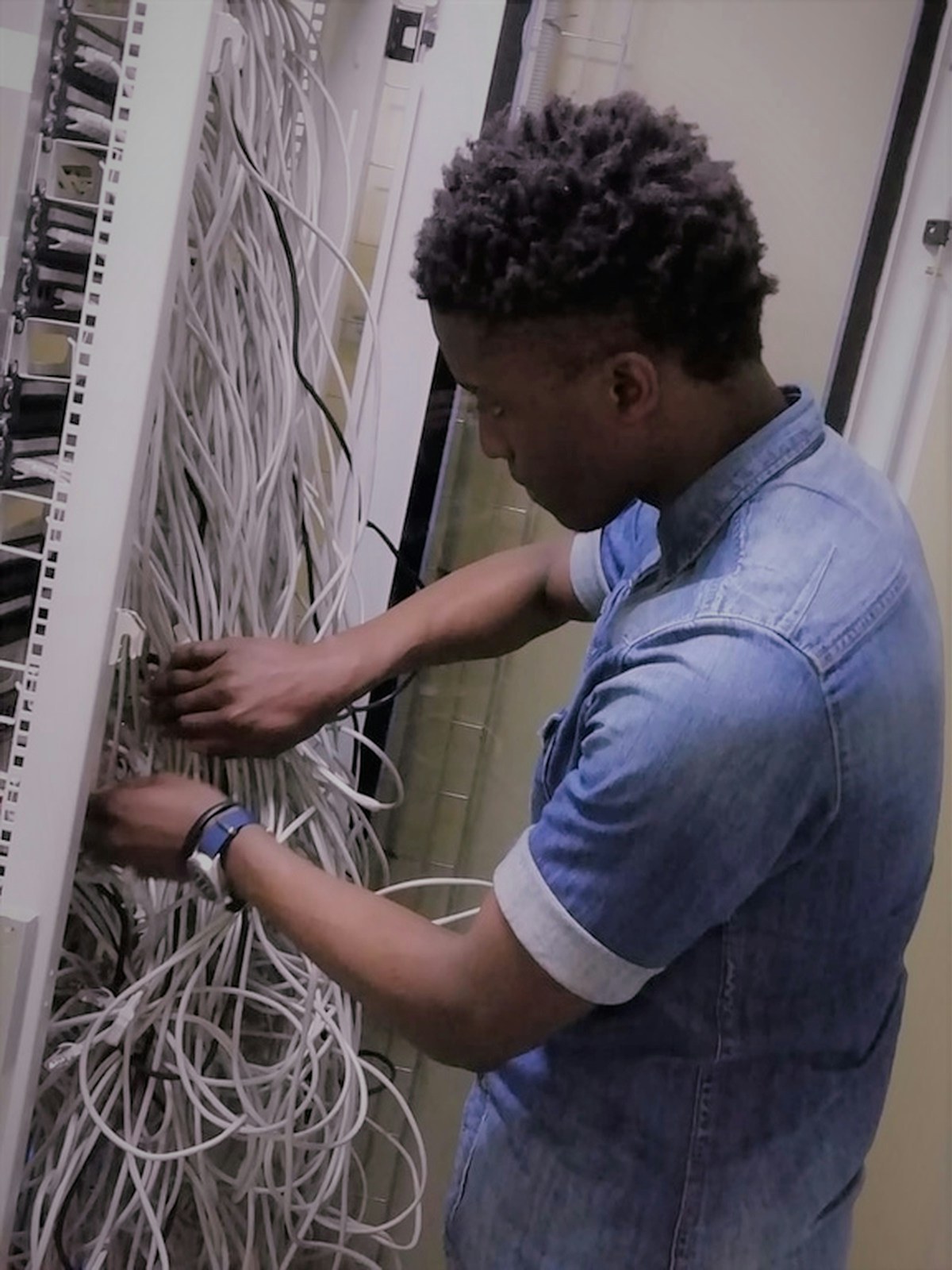 Technician wiring a network patch panel